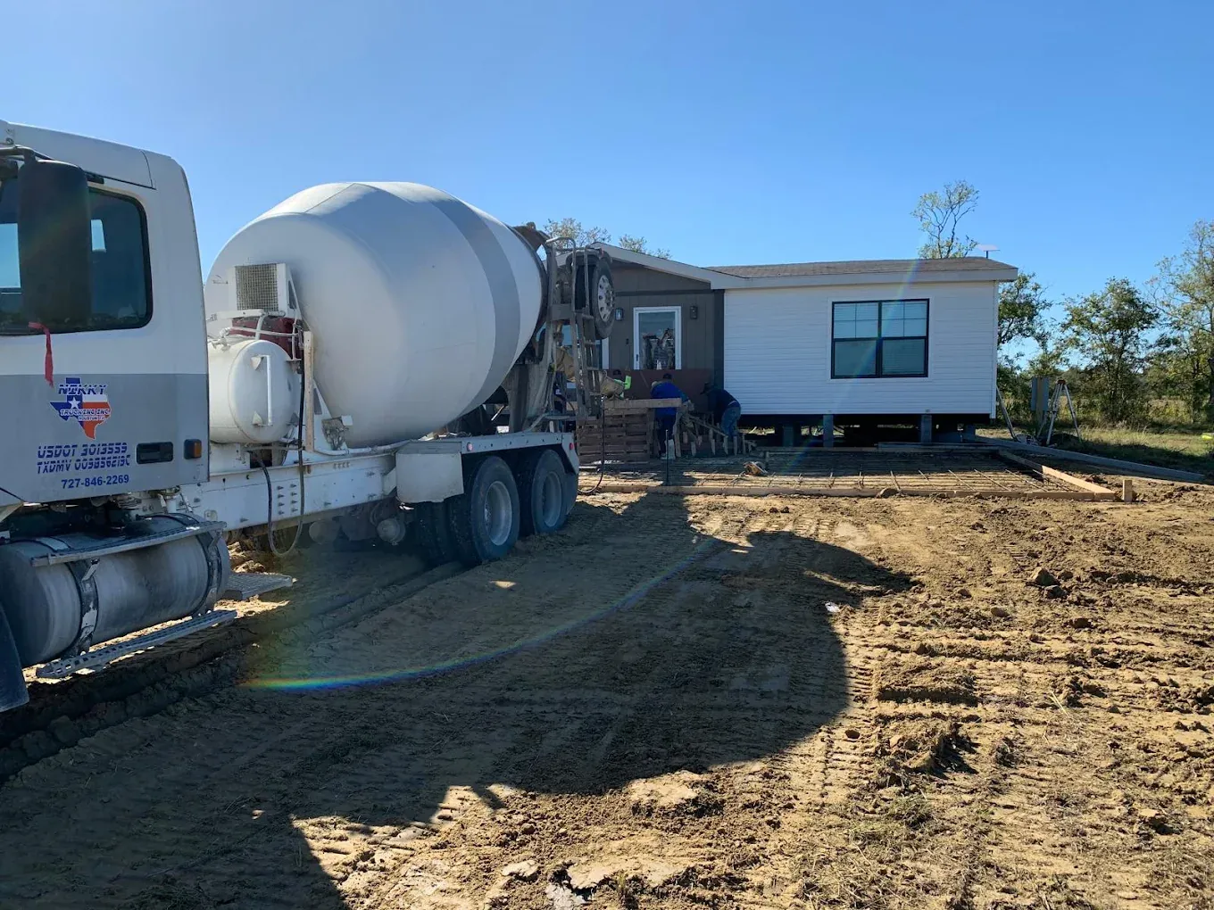 Nikky Ready Mix Concrete truck pouring a slab foundation at a residential job site in Montgomery County, TX